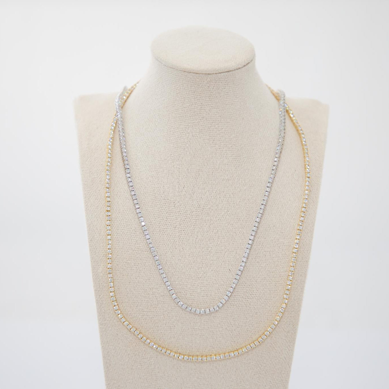 Necklace displayed on a mannequin bust against a white background